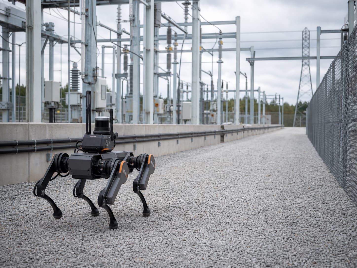 Unbranded quadruped robot inspecting an electrical substation corridor